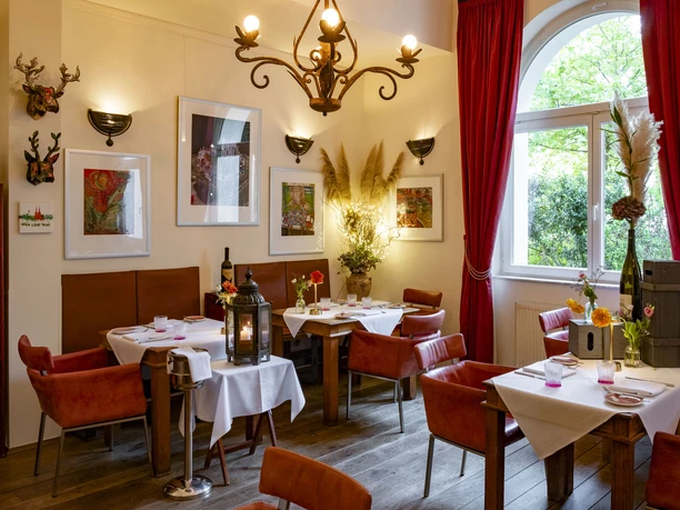 Grubers Restaurant Comfortably furnished restaurant with red leather chairs and an ornate chandelier.