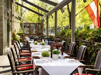 Grubers Restaurant Einladende Außengastronomie mit weißen Tischdecken gedeckte Tische.Inviting outdoor dining area with tables set with white tablecloths.