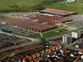 Luftaufnahme des Nixdorf Produktionswerks von 1985, mit großen roten Dächern und Parkplätzen, umgeben von Feldern.