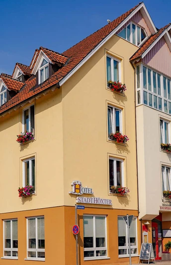Außenansicht des dreistöckigen Hotels , gelb gestrichen mit Blumenkästen