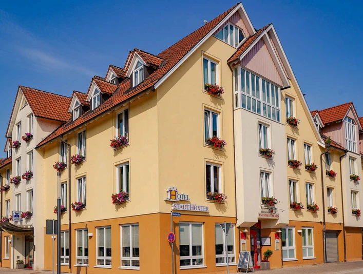 Außenansicht des dreistöckigen Hotels , gelb gestrichen mit Blumenkästen