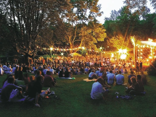 Die Freilichtbühne in der Mülheimer Altstadt Freilichtbühne in Mülheim an der Ruhr bei Abenddämmerung, mit Publikum in dichter Baumkulisse.
