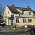 Rasthaus Wietersheim Ein zweistöckiges Restaurant mit heller Fassade und traditionellem Schild, umgeben von Parkplätzen.