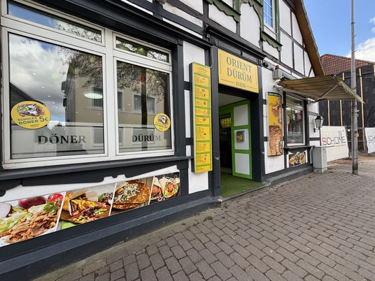Orient Dürüm Haus mit Eingangsbereich, bunter Werbetafel und großen Fenstern auf einer Kopfsteinpflasterstraße.