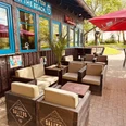 Beachbar 12 am Badesee Lahde Außenbereich einer Strandbar mit Holzmöbeln, Schildern und Sonnenschirmen nahe eines Badesees.