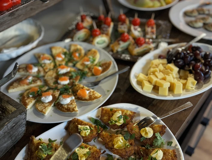Verschiedene appetitliche Fingerfood-Spezialitäten wie Käsewürfel, Oliven und belegte Brotscheiben.