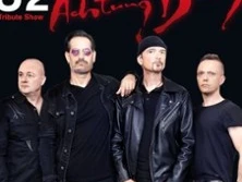 Vier Männer in dunkler Kleidung posieren vor schwarzem Hintergrund, Teil einer U2-Tribute-Show.