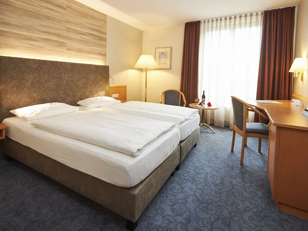 FH-StadtHoexter-Komfortzimmer-by-MarcusBrodt.jpg Hotelzimmer mit Doppelbett sowie Schreibtisch und Stuhl