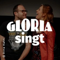 Zwei lachende Personen vor dunklem Hintergrund mit großem Schriftzug Gloria singt