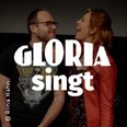 Zwei lachende Personen vor dunklem Hintergrund mit großem Schriftzug Gloria singt