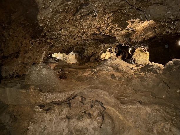 Ansicht Tropfsteinhöhle Natürliche Kalksteinhöhle mit unregelmäßig geformten Wänden und warmem Licht, das Texturen hervorhebt.