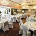 Balkes Morhoff Eleganter Festsaal mit runden Tischen, weißen Tischdecken und Kronleuchtern. Einladend dekoriert.