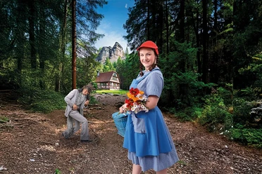Meisje met rode hoed en boeket bloemen in het bos, op de achtergrond een man en vakwerkhuis.