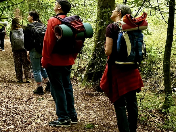 Waldbaden_2 Eine Gruppe von Wanderern im Wald, umgeben von grünem Laub und Natur, genießt einen Spaziergang.
