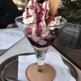 Eiscafé Venezia Ein eleganter Eisbecher mit Sahne, Fruchtsauce und Waffel im Eiscafé Venezia auf einem Tablett serviert.