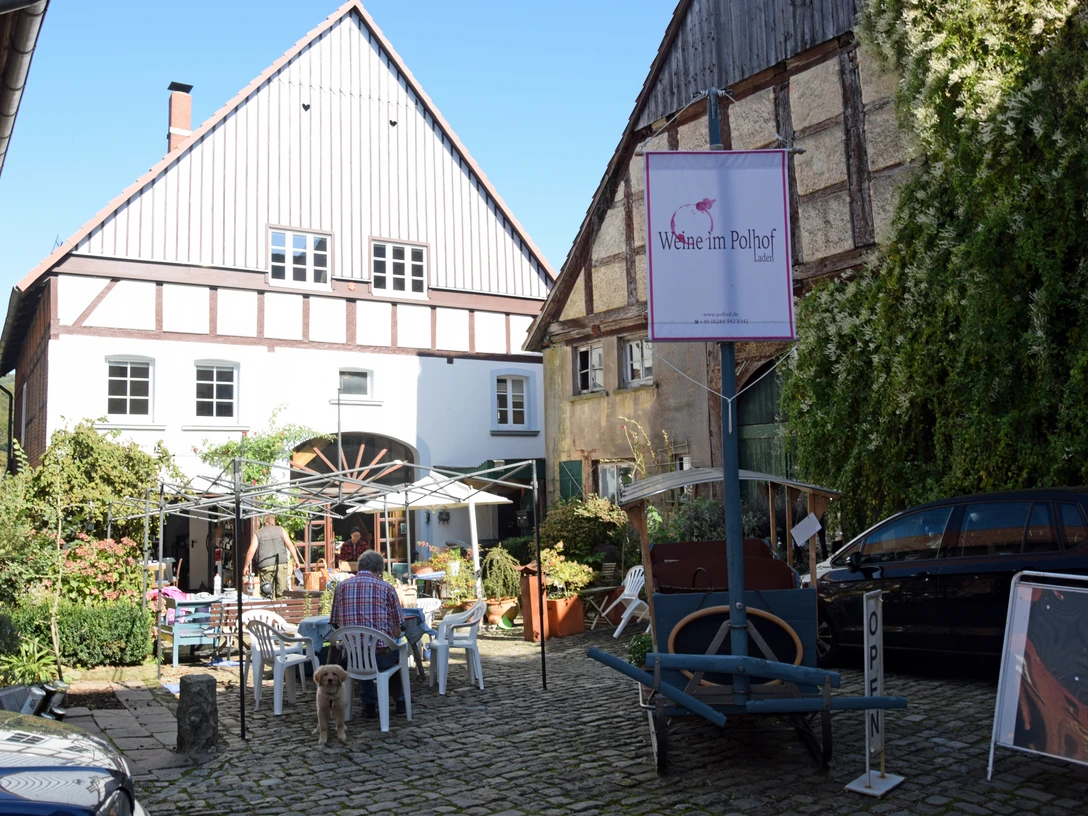 Zwei Häuser im Fachwerkstil mit einem Innenhof. Ein Restaurant bietet Sitzplätze im Freien.