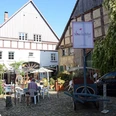 Zwei Häuser im Fachwerkstil mit einem Innenhof. Ein Restaurant bietet Sitzplätze im Freien.