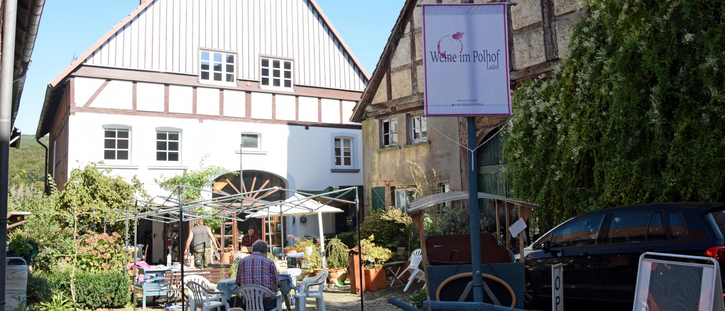 Hausvonaußen©Martina Schäfer .jpg Zwei Häuser im Fachwerkstil mit einem Innenhof. Ein Restaurant bietet Sitzplätze im Freien.