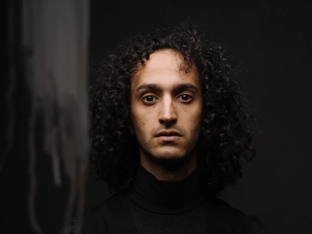 Romanischer Sommer Saxophonist Salim(a) Javaid stares intently into the camera.