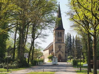 Blick durch die Eichenallee auf die evangelische Kirche Bad Driburgs..