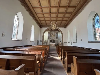 Blick durch das Kirchenschiff auf den Altarraum der evangelischen Kirche.