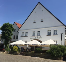 Hausansicht Anno 1700 bearbeitet für web.jpg Historisches Gebäude mit spitzem Giebel, Außenterrasse des Restaurants "Ristorante La Piazzetta".