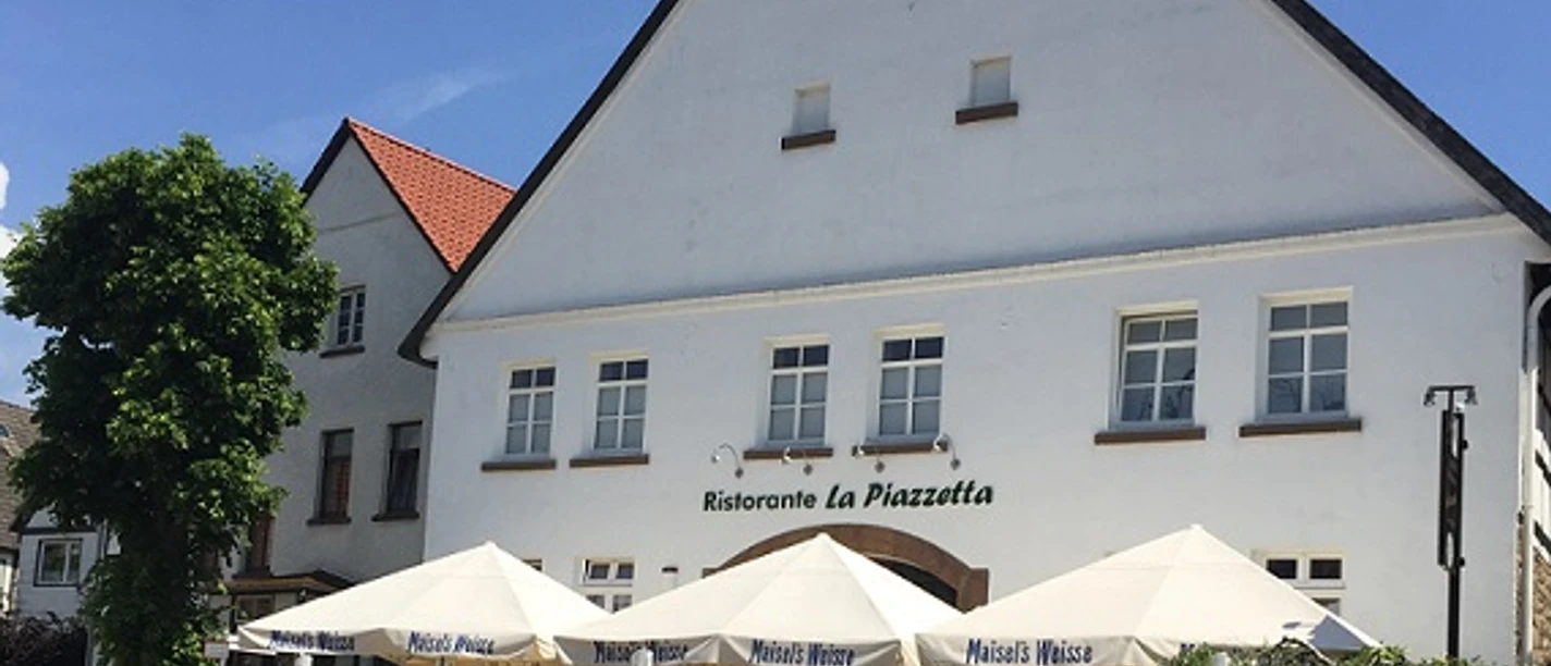 Hausansicht Anno 1700 bearbeitet für web.jpg Historisches Gebäude mit spitzem Giebel, Außenterrasse des Restaurants "Ristorante La Piazzetta".