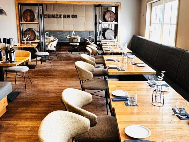 NEUNZEHN01_mittlerer Bereich_Restaurant.jpg Gastraum mit Holzfußboden, Holztischen, Stühlen und langer Polsterbank