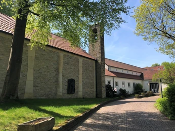 Tagungsstätte ev. Akademie Loccum Tagungszentrum in Loccum mit hellem Backsteingebäude, Glockenturm und grüner Umgebung.