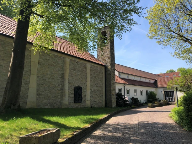 Tagungsstätte ev. Akademie Loccum Tagungszentrum in Loccum mit hellem Backsteingebäude, Glockenturm und grüner Umgebung.