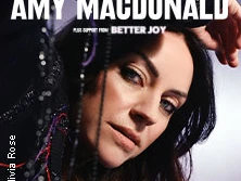 Amy MacDonald blickt intensiv in die Kamera, umgeben von zarten, dunklen Vorhangfäden.