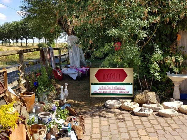 NaturGarten mit KunstObjekten - Trödelmarkt am Hofeingang Künstlerisch gestalteter Garten mit Keramikkunstwerken und einem Trödelmarkt am Eingang auf Kopfsteinpflaster.