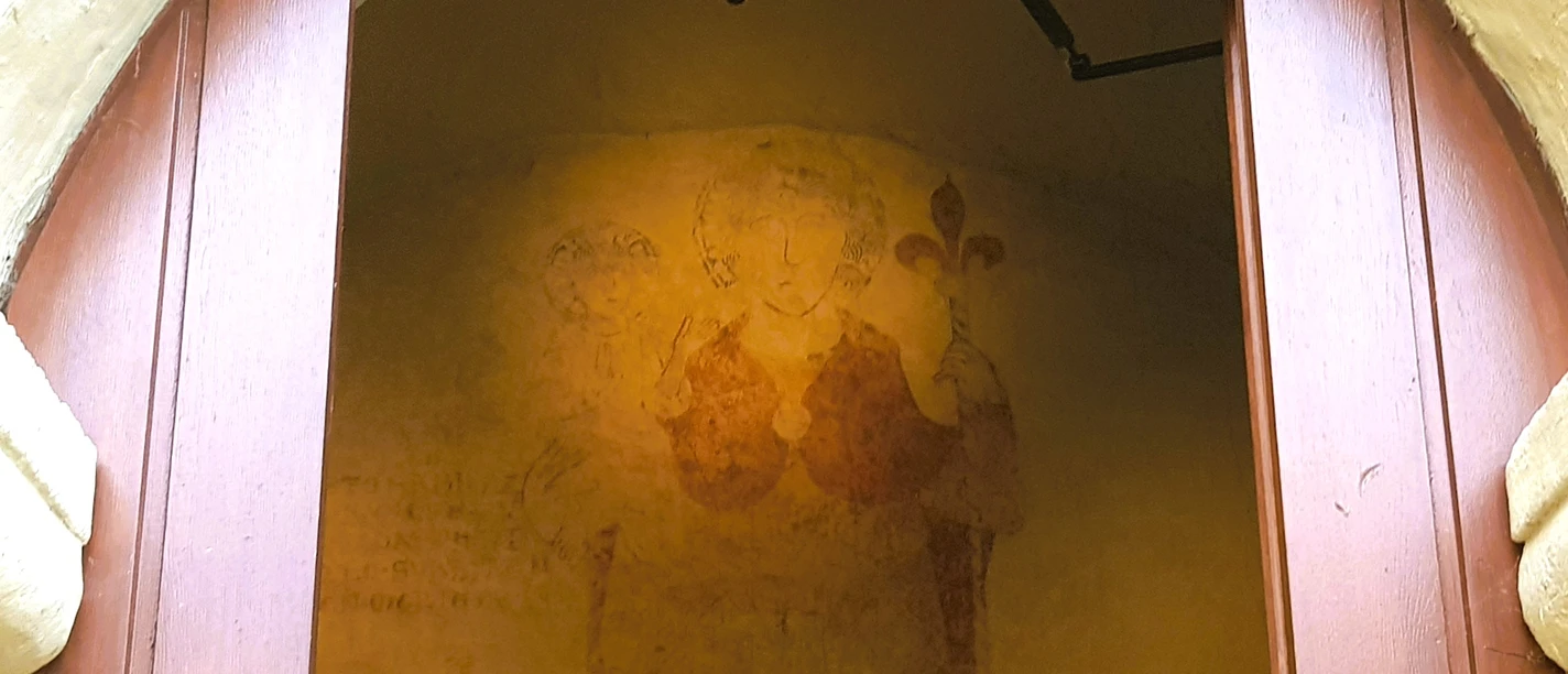 Christophorus-Wandbild.jpg Wandgemälde des Heiligen Christophorus in einem gotischen Torbogen in Schlangen, Nordrhein-Westfalen.