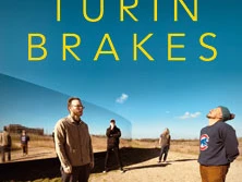 Fünf Personen stehen auf einem Feldweg vor hellem Himmel, voneinander entfernt, in entspannter Pose.