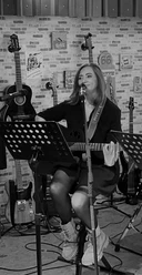 Musikerin.jpg Fünf Männer stehen nebeneinander, vier halten Musikinstrumente: zwei E-Gitarren, einen E-Bass, ein Keyboard und ein Schlagzeug mit Sticks.