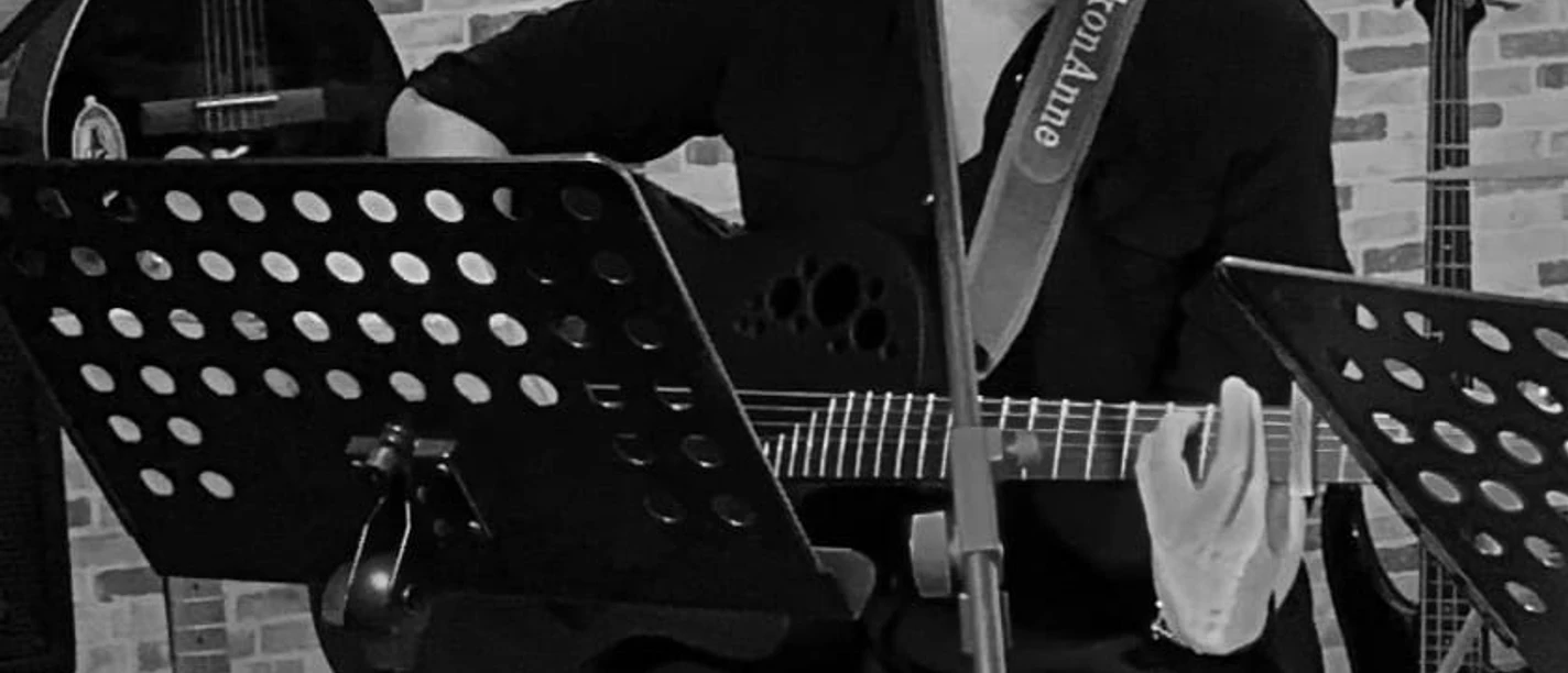 Musikerin.jpg Fünf Männer stehen nebeneinander, vier halten Musikinstrumente: zwei E-Gitarren, einen E-Bass, ein Keyboard und ein Schlagzeug mit Sticks.