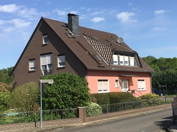 Ein rotes Backsteinhaus mit modernen Fenstern und gepflegtem Garten in einer ruhigen Wohngegend.A red brick house with modern windows and a well-kept garden in a quiet residential area.Et rødt murstenshus med moderne vinduer og en velplejet have i et roligt villakvarter.Een huis van rode baksteen met moderne ramen en een goed onderhouden tuin in een rustige woonwijk.