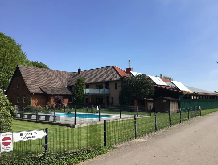 Ponyhof Hagedorn Ein Ponyhof mit mehreren Gebäuden, umzäuntem Außenbereich, Swimmingpool und Hinweisschild.A pony farm with several buildings, fenced outdoor area, swimming pool and information sign.En ponyfarm med flere bygninger, indhegnet udendørs område, swimmingpool og informationsskilt.Een ponyboerderij met verschillende gebouwen, omheind buitenterrein, zwembad en informatiebord.