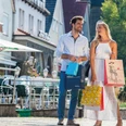 bad-driburg-shopping-bad-driburger-touristik-gmbh-daniel-winkler-2020-3 (1).jpg Ein Paar genießt einen sonnigen Einkaufstag in einer malerischen Einkaufsstraße.
