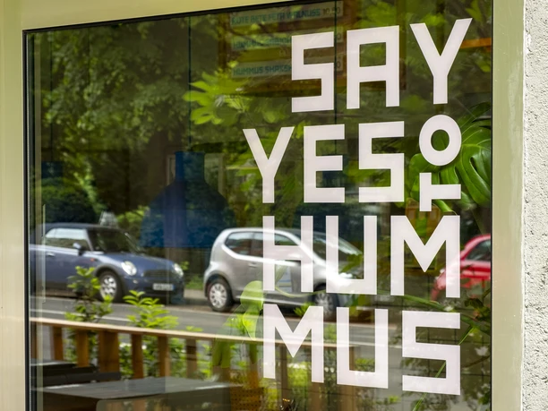 Mashery Hummus Kitchen Eine elegante Fensterfront von Mashery Hummus Kitchen zeigt den Schriftzug "Say Yes to Hummus".