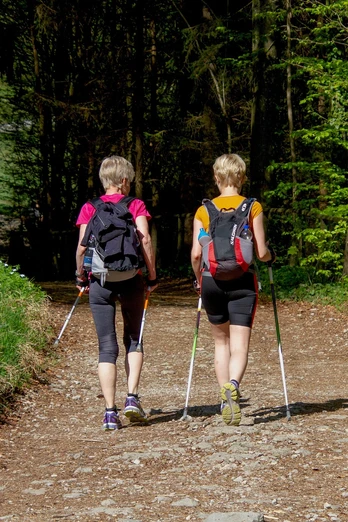 Paar mit Wanderstöcken auf dem Fitness-Parcours.