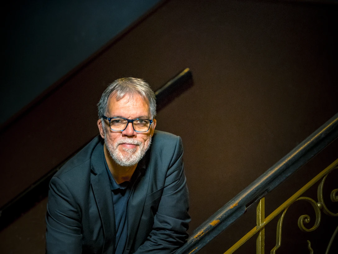 Wolfgang Trepper kommt nach Espelkamp Wolfgang Trepper lehnt lächelnd an einem kunstvoll verzierten Treppengeländer in gedämpftem Licht.