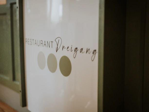 Logo des Restaurants "Dreigang" mit stilvoller Schrift und drei grünen Punkten daneben.