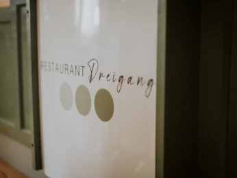 Restaurant Dreigang Herford- Lars May (4).jpg Logo des Restaurants "Dreigang" mit stilvoller Schrift und drei grünen Punkten daneben.