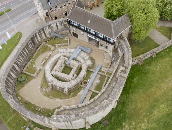 Schloß Broich, Mülheim an der Ruhr Mittelalterliche Festungsanlage mit Rundturm, umgeben von grünen Wiesen und Bäumen.