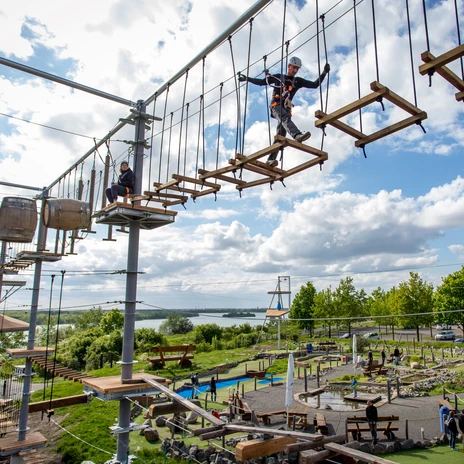 The picture shows a person conquering the course in the Markkleeberg climbing park.