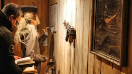 escaperoom-hof-alvermann-woltem.jpg Ein Mann und eine Frau im Escape Room, konzentriert auf Rätsel an der Wand.