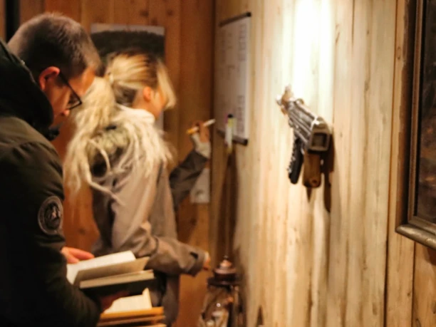 escaperoom-hof-alvermann-woltem.jpg Ein Mann und eine Frau im Escape Room, konzentriert auf Rätsel an der Wand.
