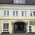 Hotel Höltje Historische Fassade von Hotel Höltje mit offenen Eingangsportal, darüber aufgereihte Fenster.
