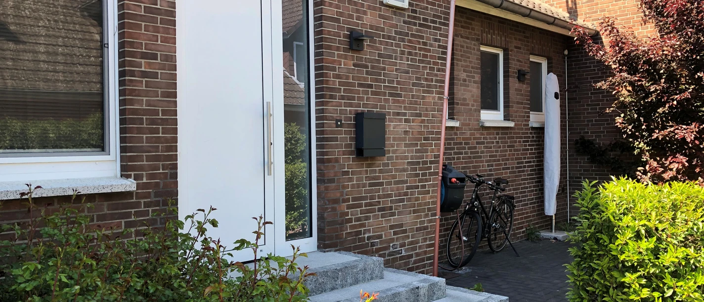 Appartement No. 16 Zwei Fahrräder stehen vor der Eingangstür eines Backsteinhauses mit kleinen Pflanzen im Vordergrund.